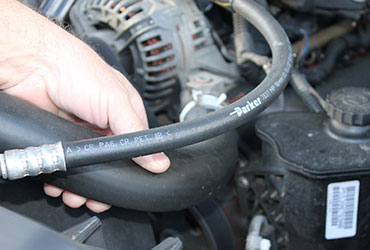Closeup of hand inspecting engine hoses