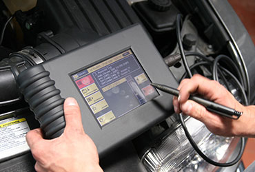 Closeup of mechanic using diagnostic device