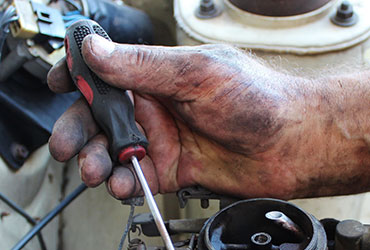 Closeup of mechanic's hand holding screw driver