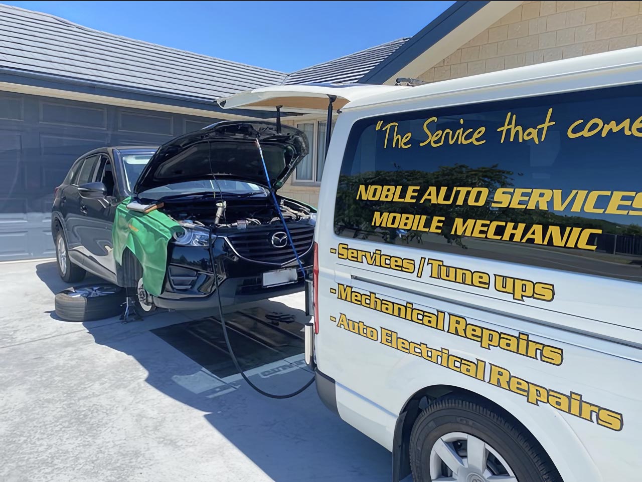 Mobile mechanic servicing a car at home in the driveway
